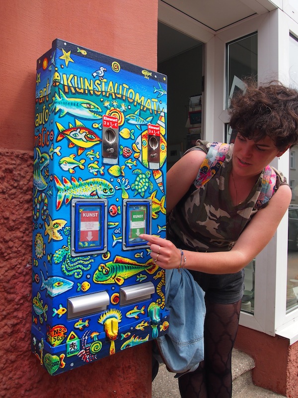 Kondomautomat? Weit gefehlt! Hier holt sich Teresa ein “Päckchen Kunst” vom Kunstautomat – ein witziges Detail unseres Besuches in Rostock.
