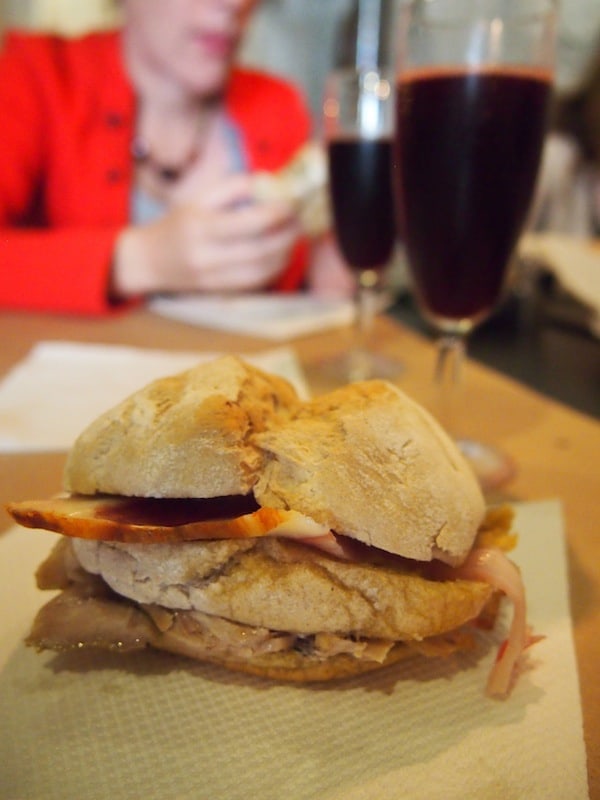 Hier genießen wir ein einzigartiges Sandwich, gefüllt mit köstlich duftendem Fleisch und Speck, dazu ein Glas prickelnden Rotweins ...