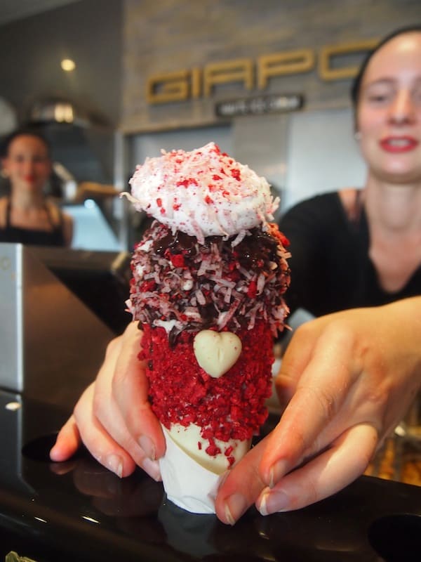 Nachdem ich mich unter all den hervorragenden Sorten schweren Herzens für die "New Zealand Lamington Ice Cream in a Chocolate Raspberry Cone with a big Marshmallow Hat on Top" entschieden habe, wird mir diese außergewöhnliche Kreation feierlich überreicht. (!).