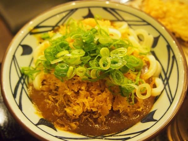 Main course is for Japanese noodles in a sweet curry sauce complete with spring onions and deep fried crisps, at "one of my favourite places", Dannie smiles.