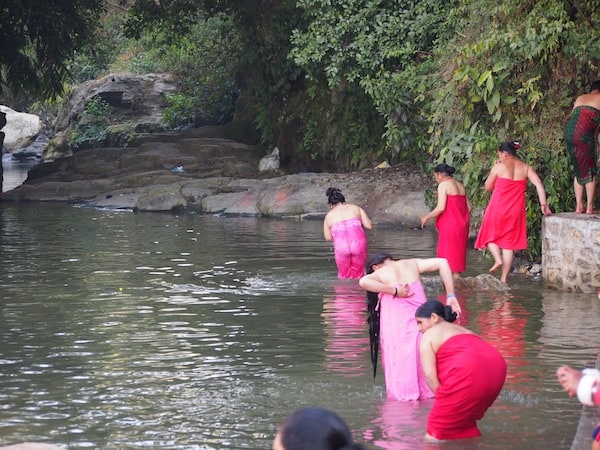 ... draws the crowds and many religious believers, including these women taking their ritual baths in the local river Sali ...
