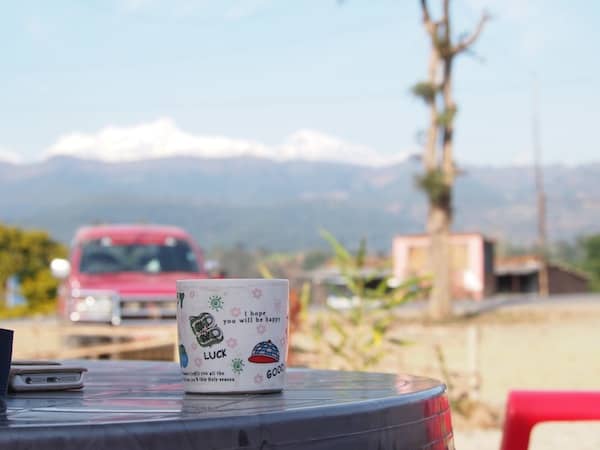 Time for a coffee break by the road: Lucky travellers with a view of Rakesh' Jeep (much needed in later road conditions, as we would find!) and the mountains beyond.