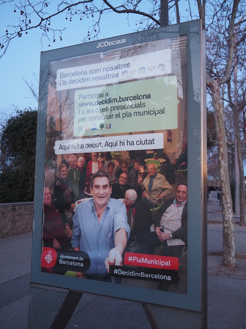 Nettes Detail am Rande: Ein Selfie-Hashtag-Werbeplakat proklamiert die Bürgerbeteiligung am Geschehen in der Stadt Barcelona.