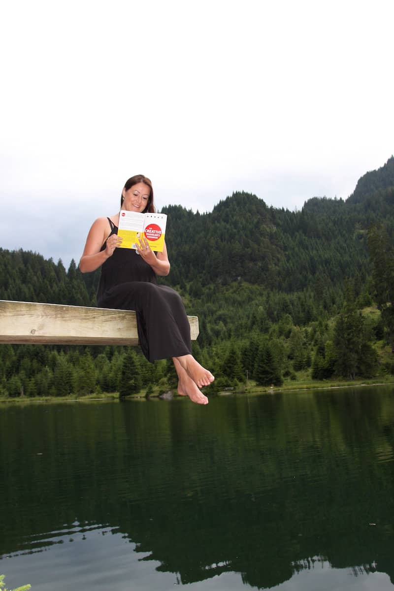 Christina mit meinem Buch, "The Creative Traveler's Handbook", an einem ihrer Lieblingsseen in Tirol.