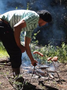Mitten im Wald machen wir Mittagspause: Hier bereitet Facundo unser Mittagessen, gewürzte „Salchichas“ auf dem Holzspieß, für uns zu.