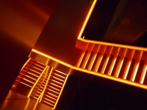 "Glühende Stiegenaufgänge" symbolisieren mittels spannender Lichttechnik den Bogen aus Steinkohleförderung, Kokerei (Kohlegewinnung) und glühendem Eisen der Schwerindustrie, für die Koks zur Befeuerung verwendet wurde.