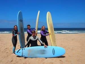 Gut lachen haben: Am dritten Tag unseres Surfcamps machen wir nicht nur eine gute Figur in unseren Wetsuits, sondern surfen auch tatsächlich schon viel besser als ganz zu Beginn. Es ist ein ganz besonderer Lifestyle, hier am Strand von Portugal.