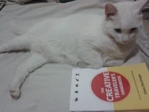 Antonia enjoy "The Creative Traveler's Handbook" as much as her cat.
