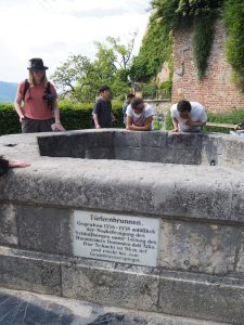 Wasser, das Sigrid Alber demonstrativ in den Türkenbrunnen schüttet, braucht viele Sekunden um anzukommen: Knapp 100 Meter tief ist dieser historische Brunnen auf dem Schlossberg Graz!