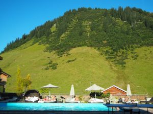 Das Spiel der Gegensätze: Moderne Pool-Landschaften vor dem Hintergrund traditioneller Bergwiesen am höchsten Pass des Großen Walsertales ...