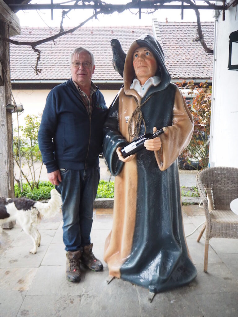 Josef Wilhelm, einer der Apfelmänner in der Region Puch bei Weiz, posiert mit einer Apfelmann Statue neben seiner Brennerei. 