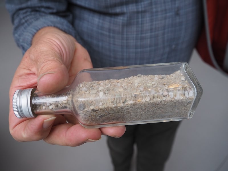 Eine mit reichhaltigem Sand gefüllte Glasflasche im Glazenhuis Museum in Lommel (Flandern)