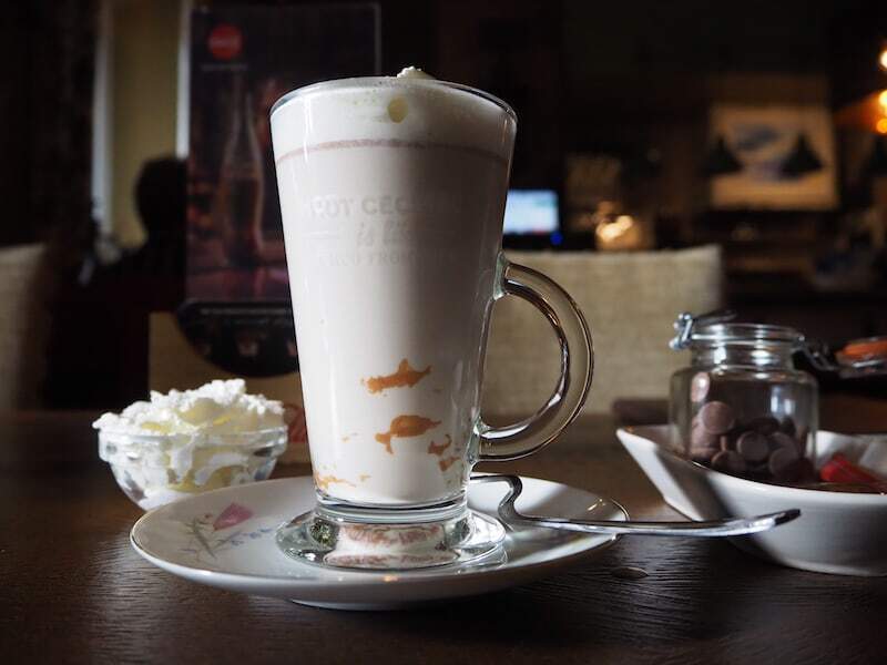 Ein Glas heiße Schokolade im Hof Ten Vrede umgeben von antiken Möbeln.